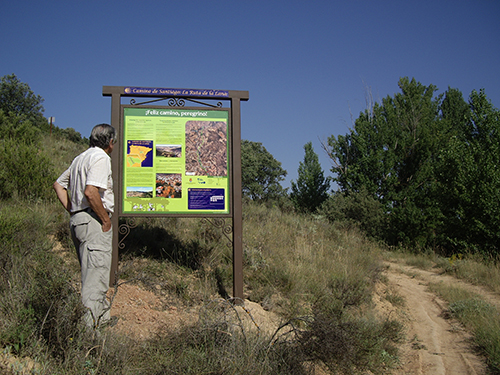 Un peregrino ante un cartel de la ruta El Camino de Santiago-Ruta de la Lana