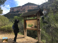 Senderista ante un panel de la ruta
